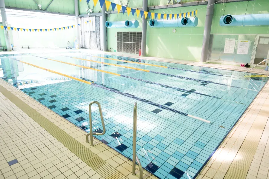 室内温水プールで運動を楽しむ利用者