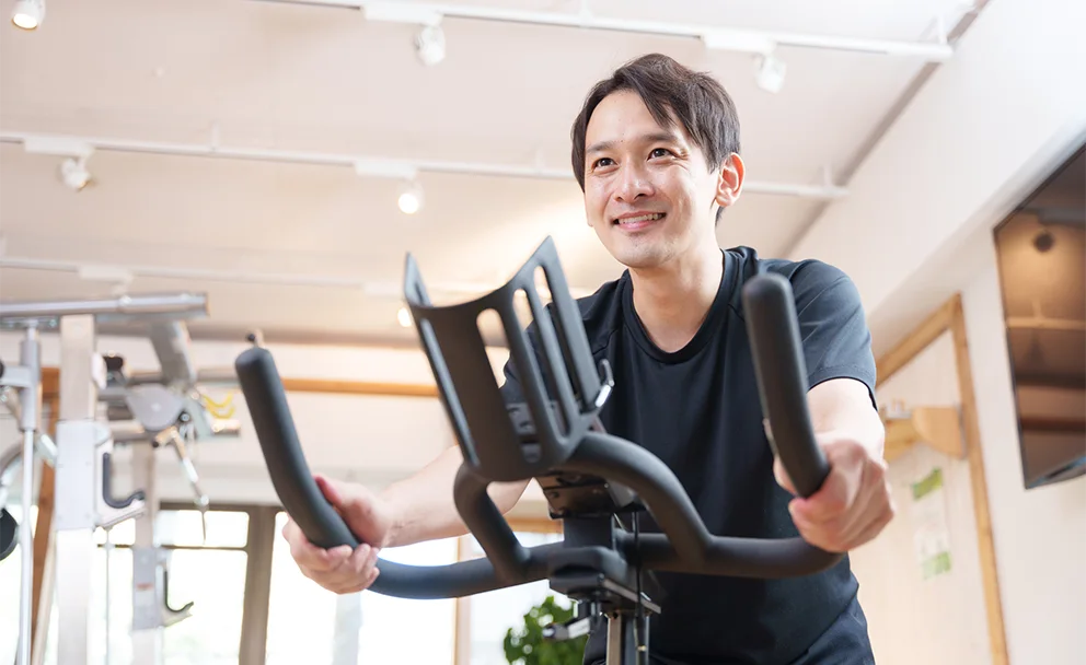 フィットネスバイクで運動する男性
